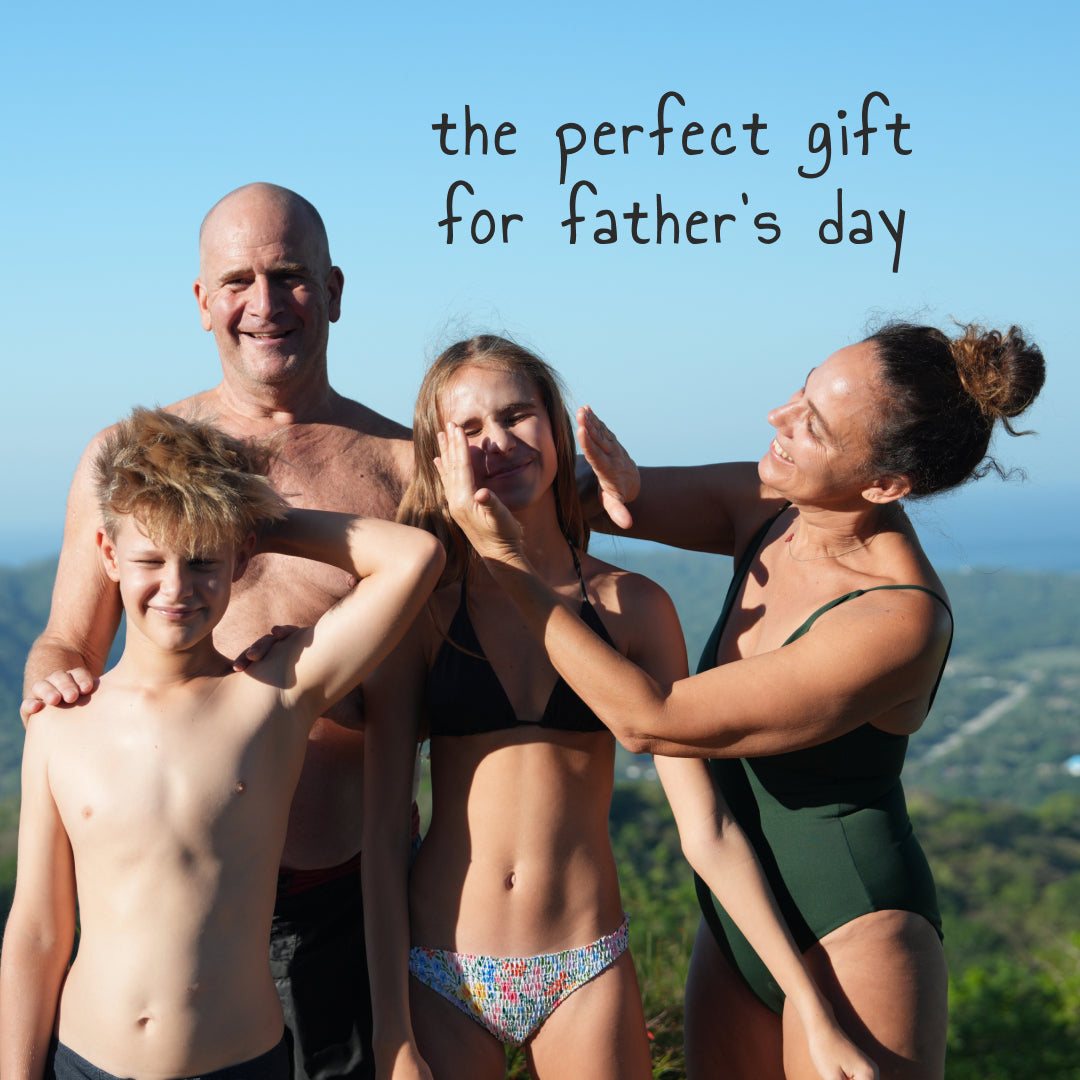 Family of four in swimsuits with text 'the perfect gift for father's day' against a scenic background.