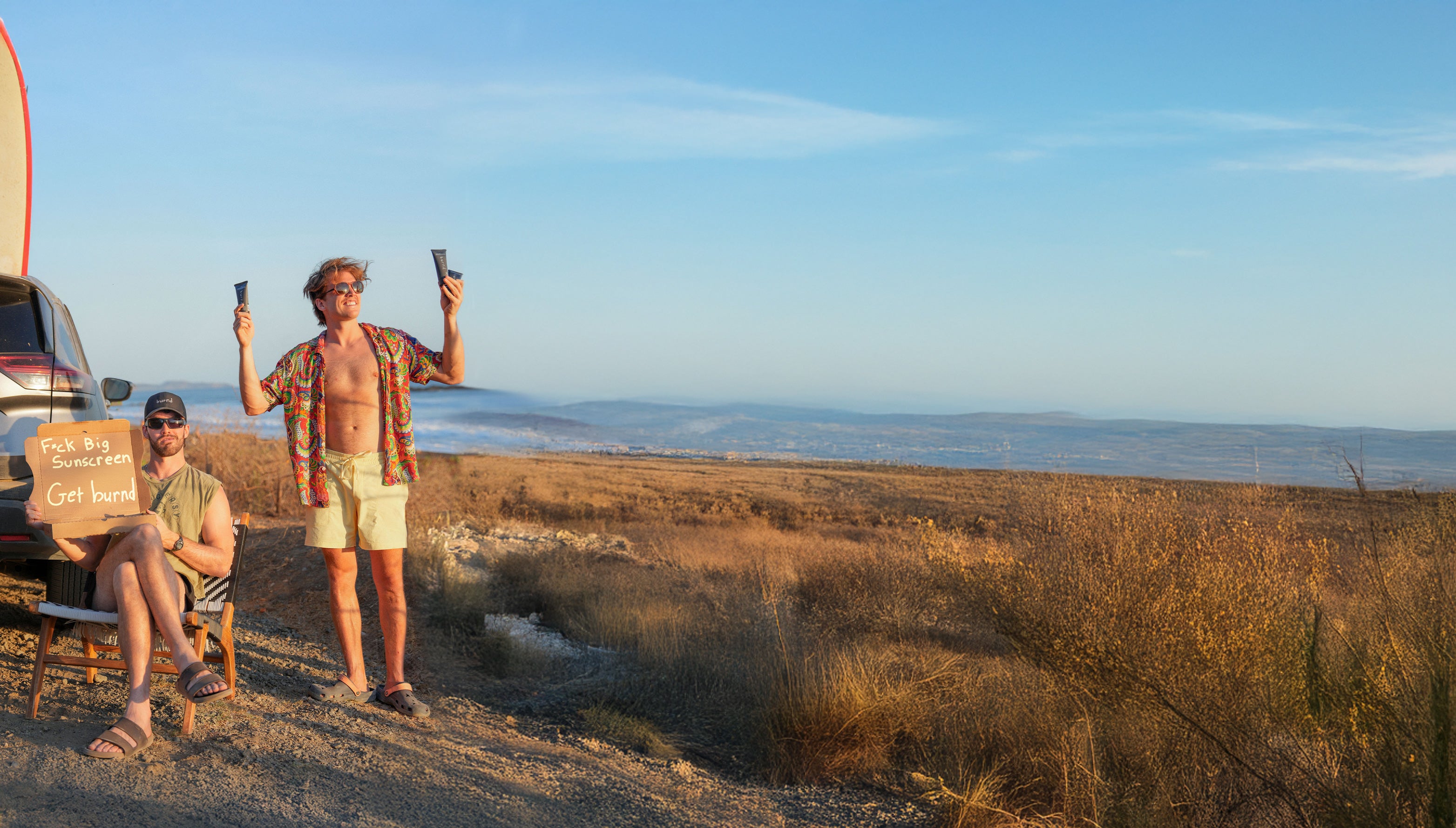 Two people with a camper van in a desert landscape with Burnd SPF41 sunscreen